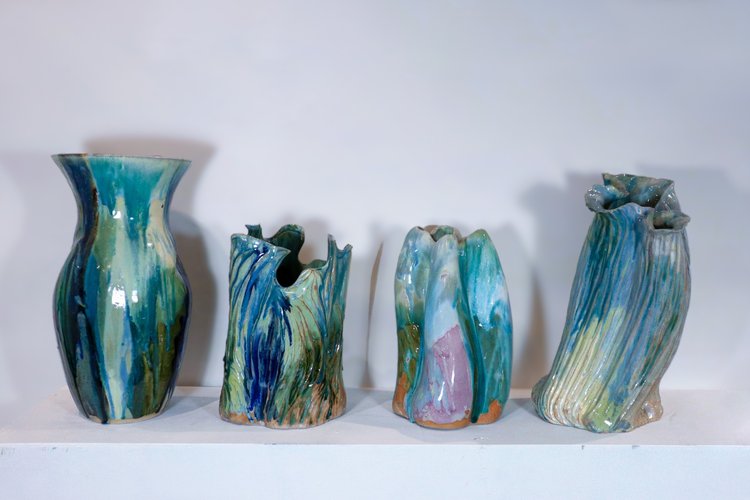 Four glazed stoneware vases in a row