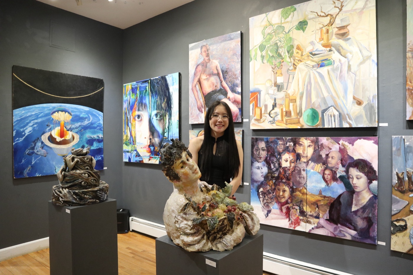 Carolanne Jiang with her paintings and sculptures at a gallery exhibition