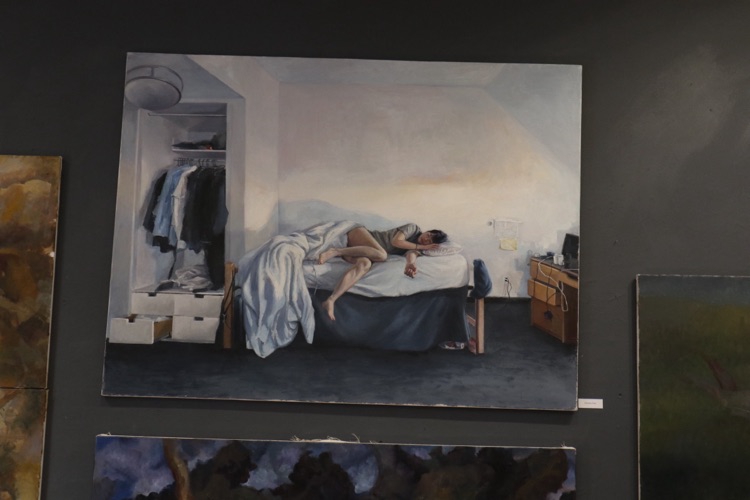 Painting of a sleeping figure hung in a gallery