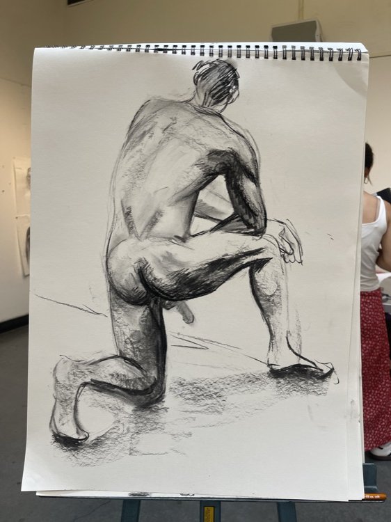 Charcoal figure drawing in a sketchbook