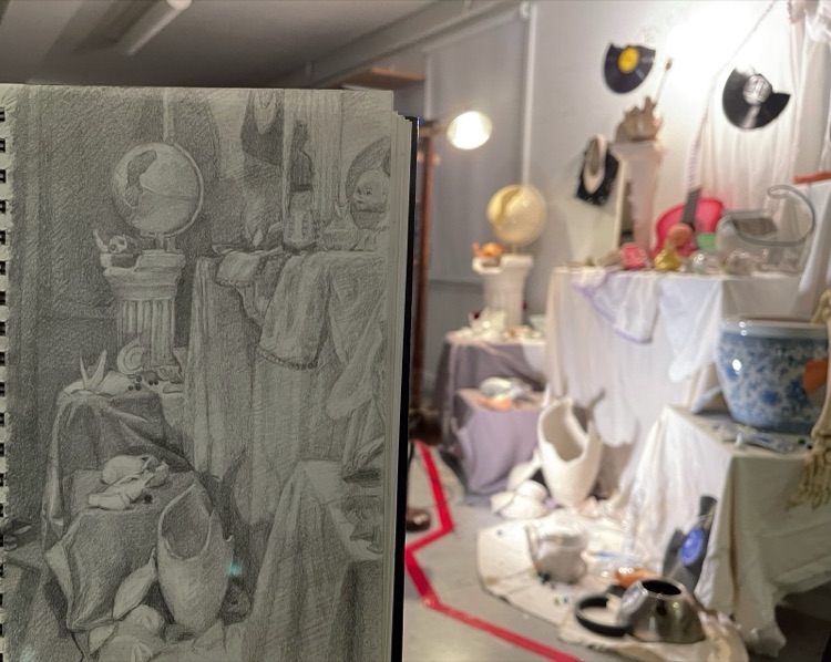 Sketchbook drawing in front of a still life installation