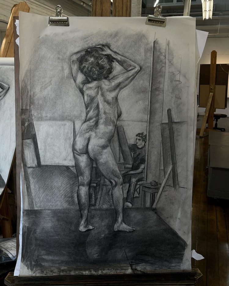 Charcoal figure drawing clipped to a board