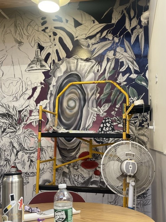 Mural in progress behind scaffolding